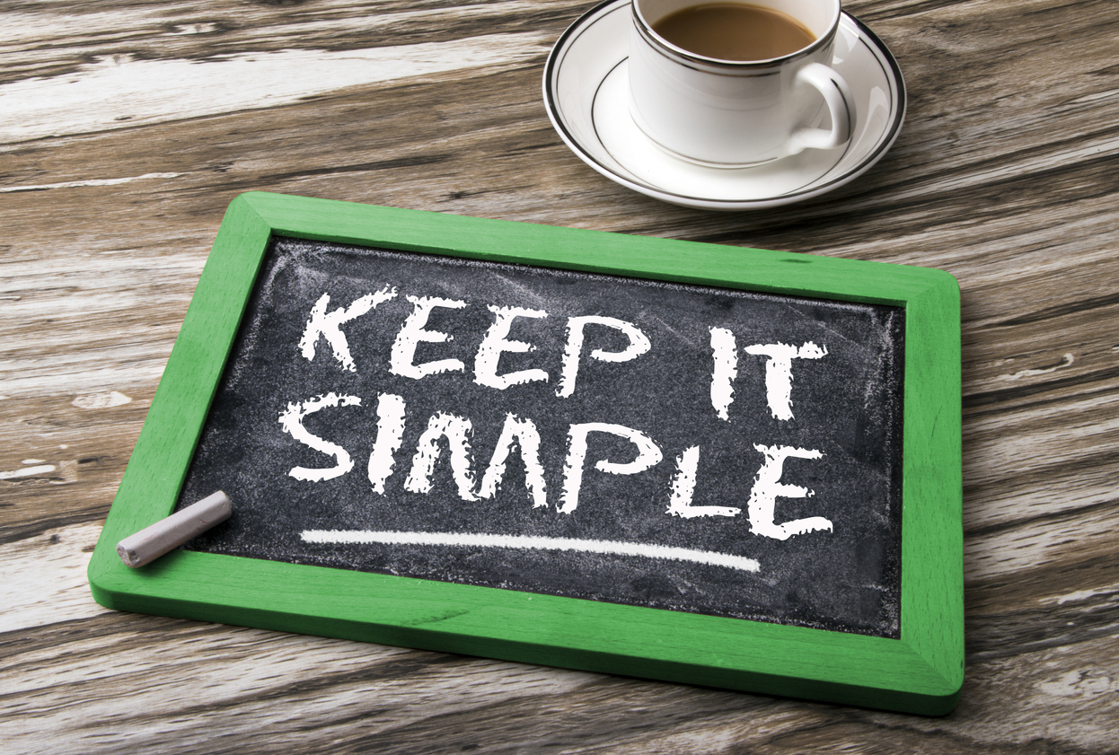 A sign on a small chalkboard that says Keep it simple