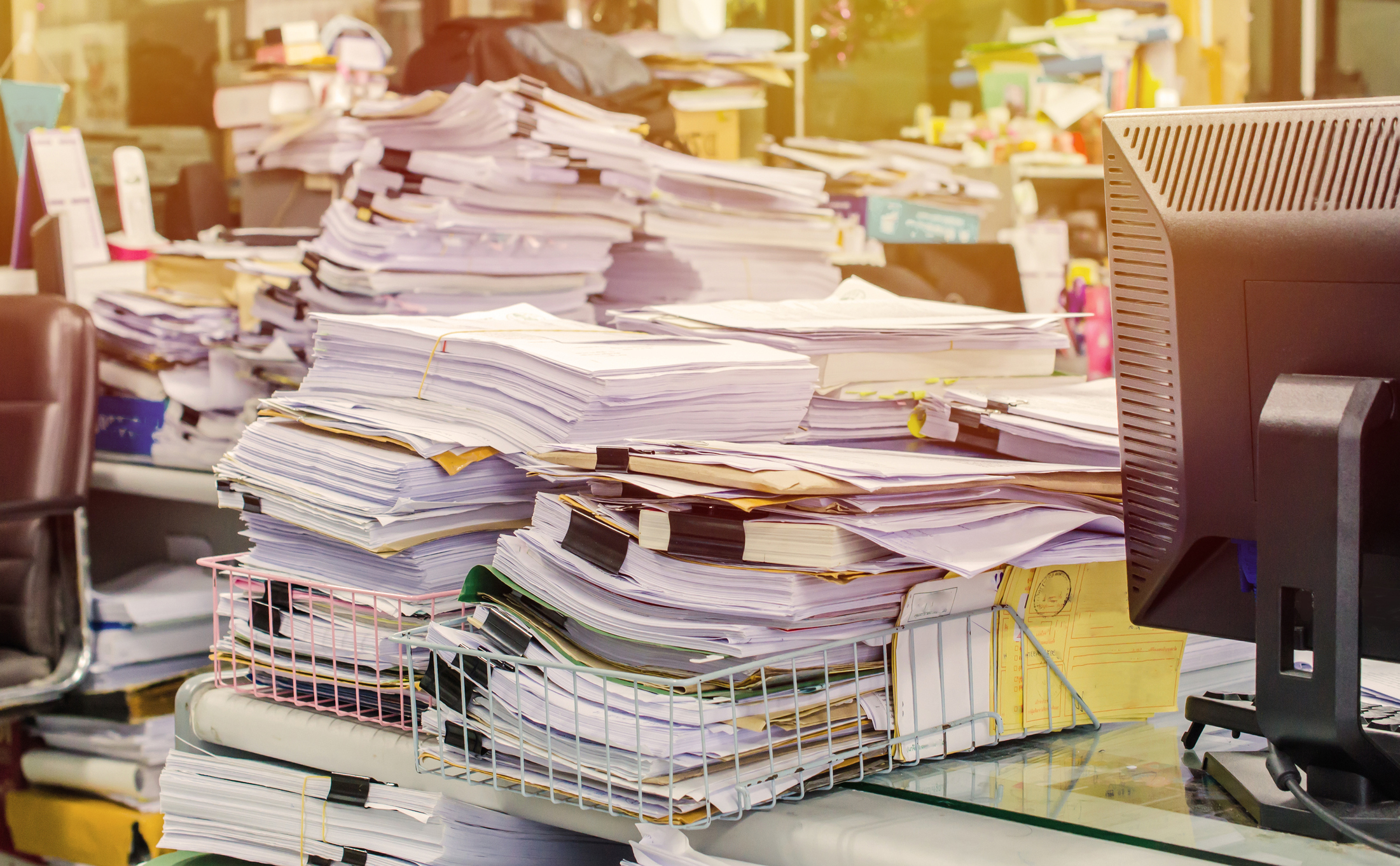 stacks of papers and files on a desk in an office