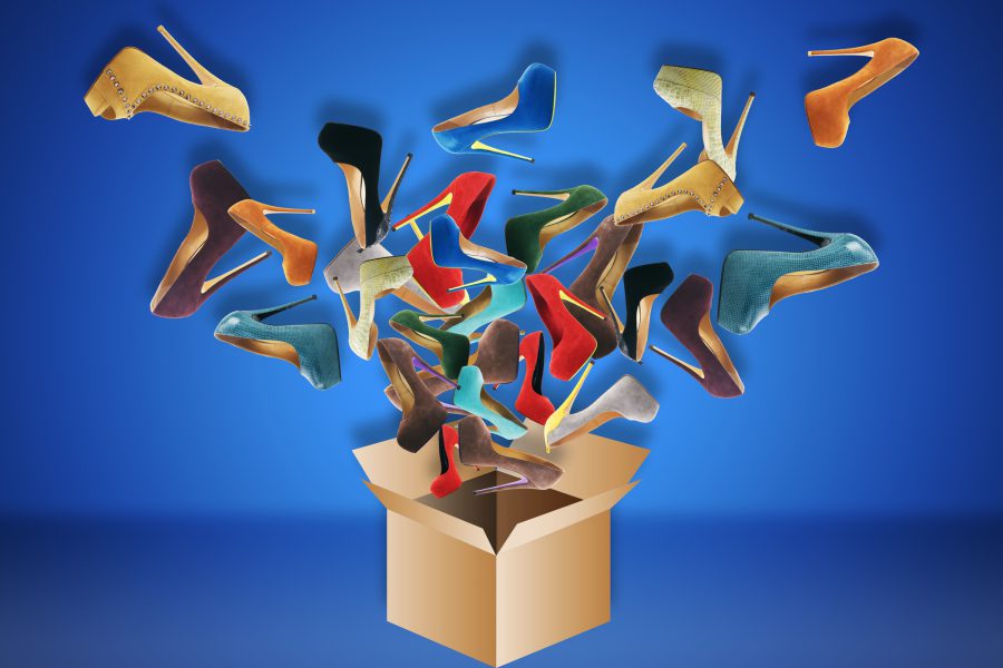 an open cardboard box with colorful high-heeled shoes flying out of it