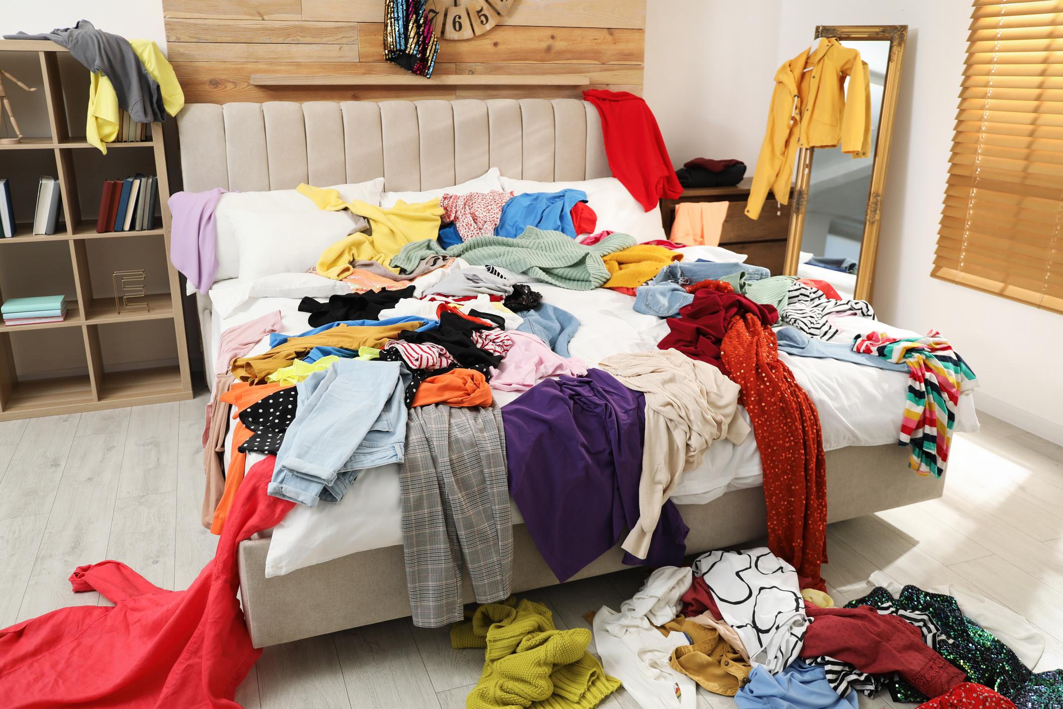 a bed covered with lots of clothes