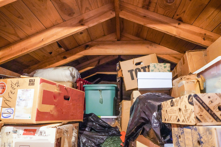 An attic space with piles of boxes and luggage