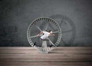 man running in a wheel getting no where and feeling overwhelmed.