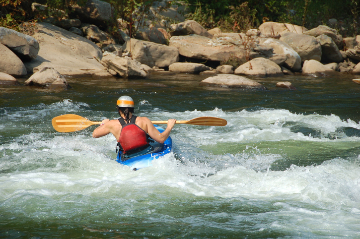 kayaker navigating change in the rapids