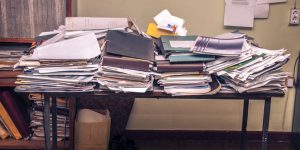 Piles of paper on top of a desk